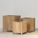 Wooden planter box set on a wooden floor against a plain wall