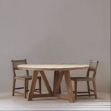Wooden dining table with two chairs against a plain wall.