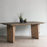 Reclaimed pine wood dining table with two potted plants on a plain background