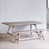Reclaimed pine wood dining table with bench in a minimalistic room