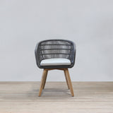 Chair with rattan backrest and wooden legs on a light wooden floor and white wall background