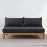 Dark gray sofa with wooden frame against a white wall