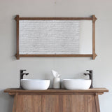 Wooden bathroom vanity with two white sinks and a mirror in a room.