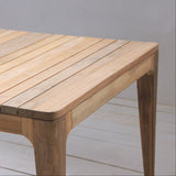 Wooden outdoor table with a leaf bowl on a light wooden floor.