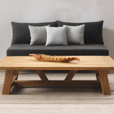 Modern outdoor sofa set with a wooden coffee table and gray sofa against a neutral wall.