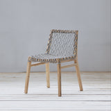 Chair with woven backrest on a white floor and gray wall