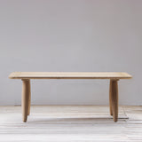Wooden table on a wooden floor with a plain white wall background
