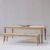 Outdoor dining table with slatted top on a wooden floor.