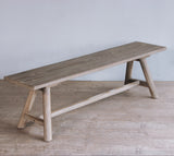 Reclaimed pine wood bench with a minimalist design on a wooden floor.