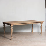 Wooden table with turned legs in a minimalistic room.