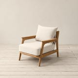 Wooden longue chair with white cushions on a wooden floor against a plain wall