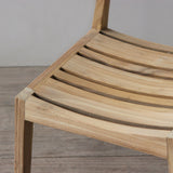 Wooden chair with slatted design on a wooden floor.