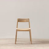 Wooden chair on a wooden floor with a plain white wall background