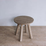 Reclaimed pine wood end table on a wooden floor with a plain white wall background