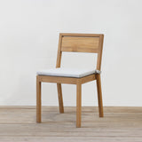 Wooden chair with a grey cushion on a wooden floor and light gray wall background