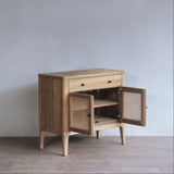 Wooden sideboard with open doors against a plain wall