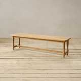 Wooden bench on a wooden floor with a plain background