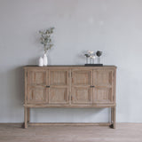 Reclaimed pine wood sideboard with decorative items against a gray wall