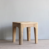 Wooden end table against a plain wall