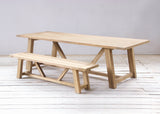 Wooden dining table and bench on a wooden floor.