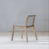 Wooden chair with woven backrest on a wooden floor against a gray wall