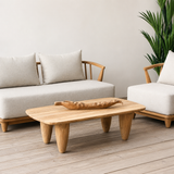 Wooden coffee table with a decorative bowl on a wooden deck, surrounded by a sofa and chair.