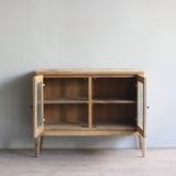 Wooden cabinet with open doors in a minimalistic room.