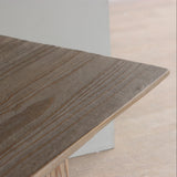 Reclaimed pine wood table top with a natural grain pattern on a light wooden floor.