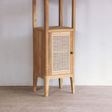 Wooden cabinet with a rattan door against a plain wall