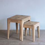 Wooden nesting table with a geometric pattern on a plain background