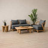 Outdoor wooden sofa set with white cushion on a wooden floor against a plain wall