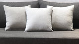 Decorative pillows on a greyish black sofa.