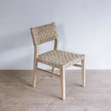 Seagrass woven chair on a wooden floor with a white wall background