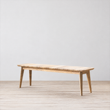 Outdoor wooden bench with slatted top on a wooden floor.