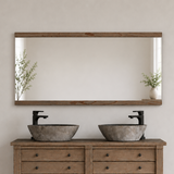 Rectangular mirror above a wooden bathroom cabinet