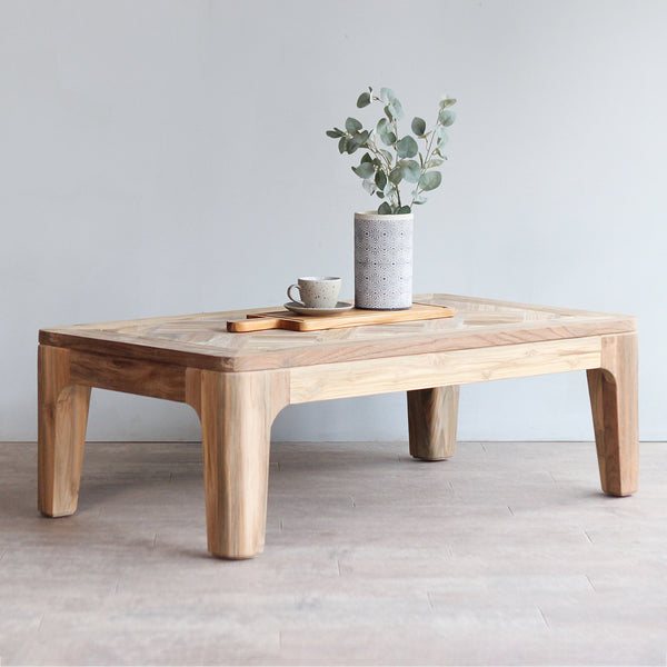 Arch Coffee Table with wooden serving board, a cup and vase on it.