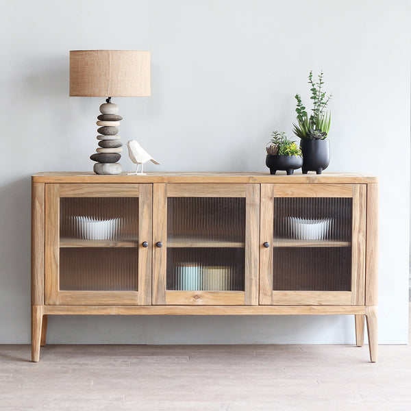 Arch Sideboard with pebbles lamp and decorative plants on top of it.