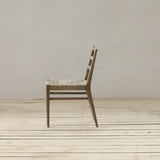 Wooden chair on a wooden floor with a plain white wall background