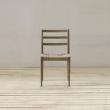 Wooden chair with woven seat on a wooden floor and white wall background