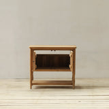 Wooden side table against a plain wall on a wooden floor
