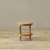 Wooden stool on a wooden floor with a plain wall background