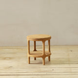 Wooden end table on a wooden floor with a plain wall background