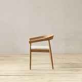 Wooden chair on a wooden floor with a plain white wall background