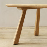 Wooden outdoor dining table on a wooden floor with a neutral background