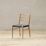 Outdoor chair with synthetic rattan seating on a wooden floor.