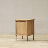 Wooden cabinet on a wooden floor with a plain wall background