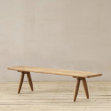 Wooden bench on a wooden floor with a beige wall background