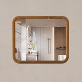 Rectangular mirror with wooden frame on a beige wall