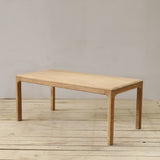 Wooden table on a wooden floor with a plain background