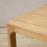 Wooden table with a natural finish on a wooden floor.